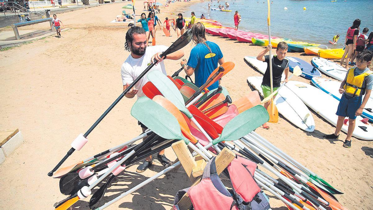 Uno de los monitores recoge las palas después de realizar actividades acuáticas.