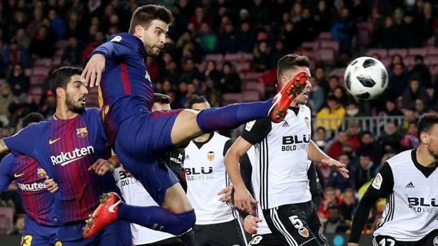 Gerard Piqué, rematant en el partit contra el València.