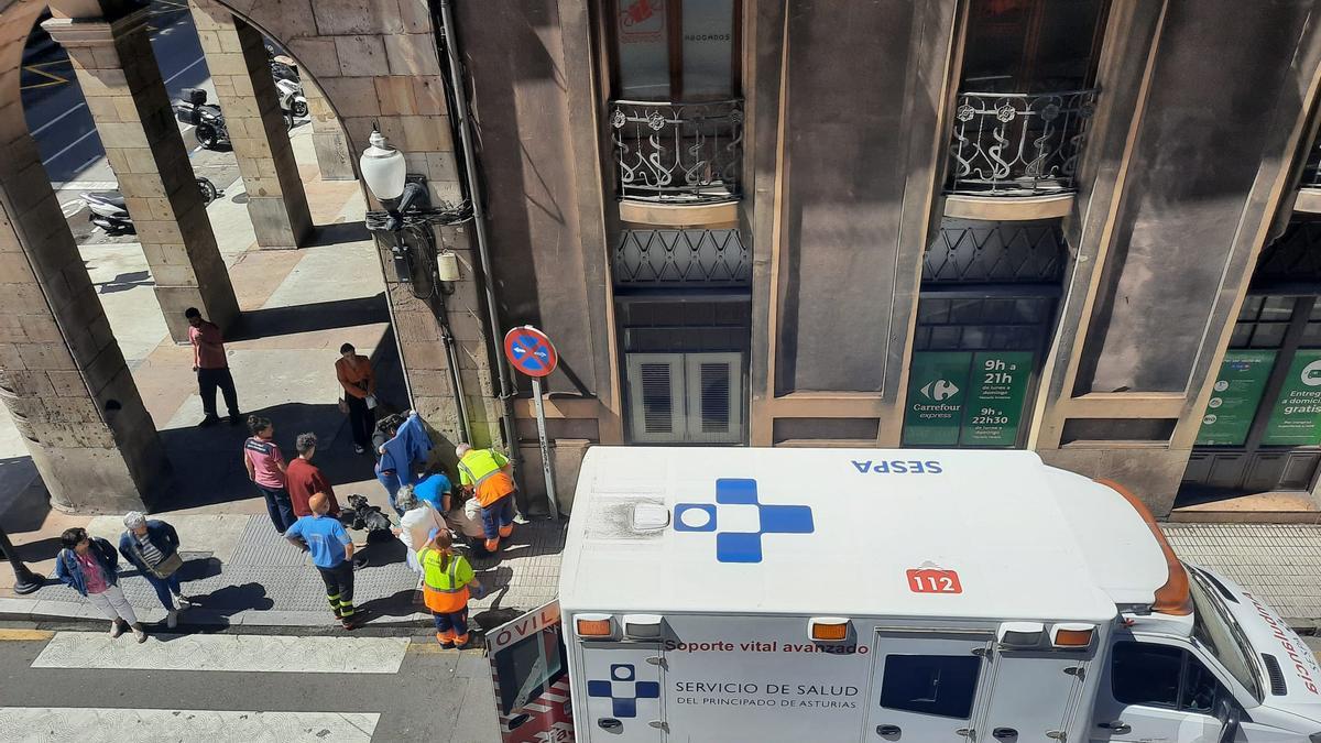 Los sanitarios, atendiendo a la afectada, ayer, en la calle Felipe Menéndez.