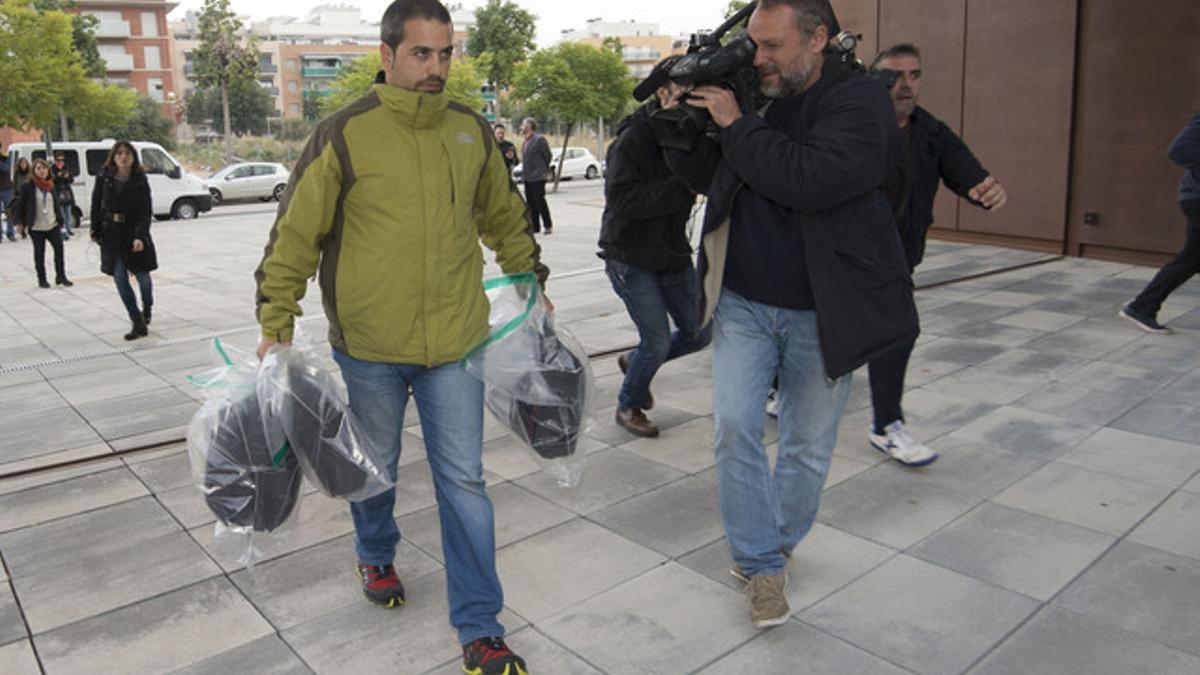 Un funcionario entrega en los juzgados de El Vendrell los tres maletines incautados en los registros de CDC.