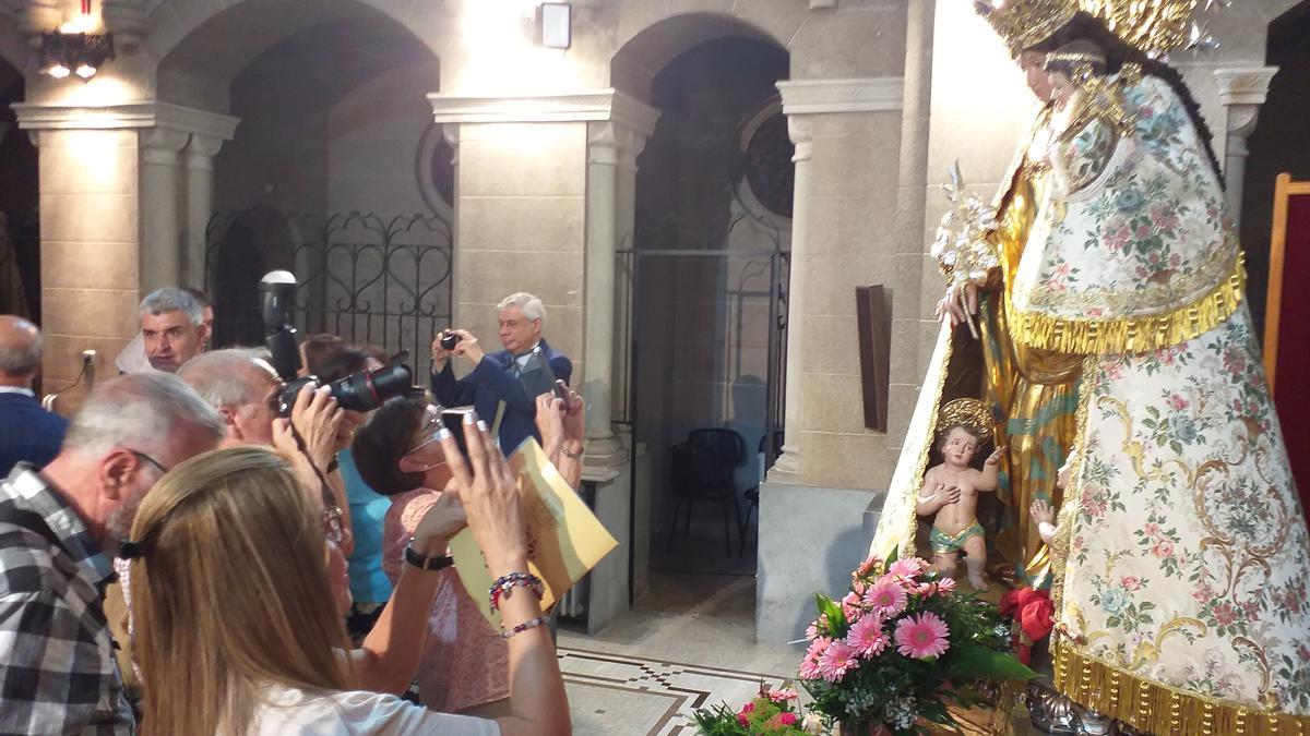 Un grupo de fieles fotografía la talla recién restaurada por Pedro Arrue.