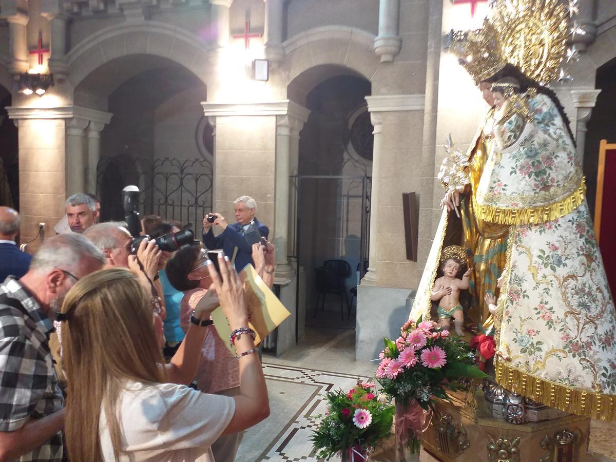 Un grupo de fieles fotografía la talla recién restaurada por Pedro Arrue.
