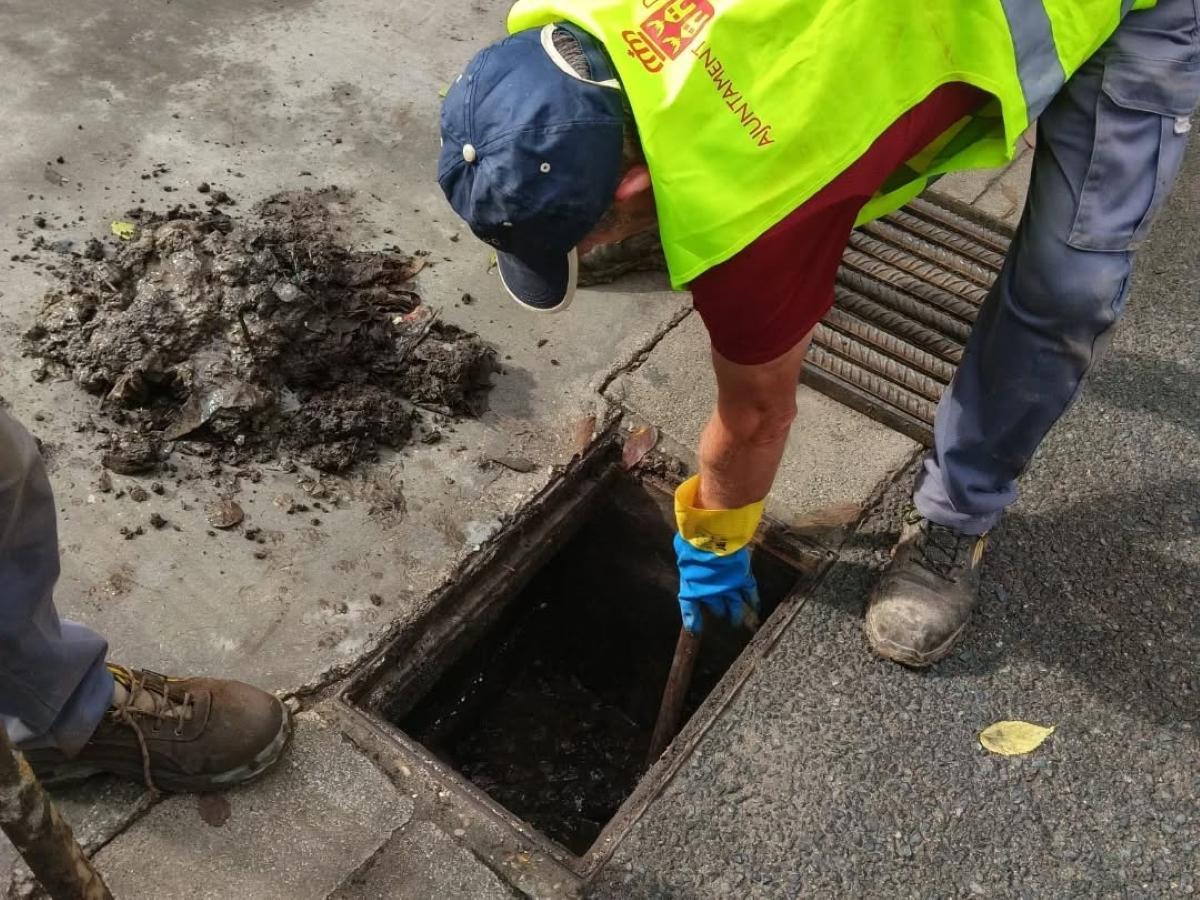Un operario del Ayuntamiento de l'Alcúdia limpia un imbornal, en una imagen de archivo.