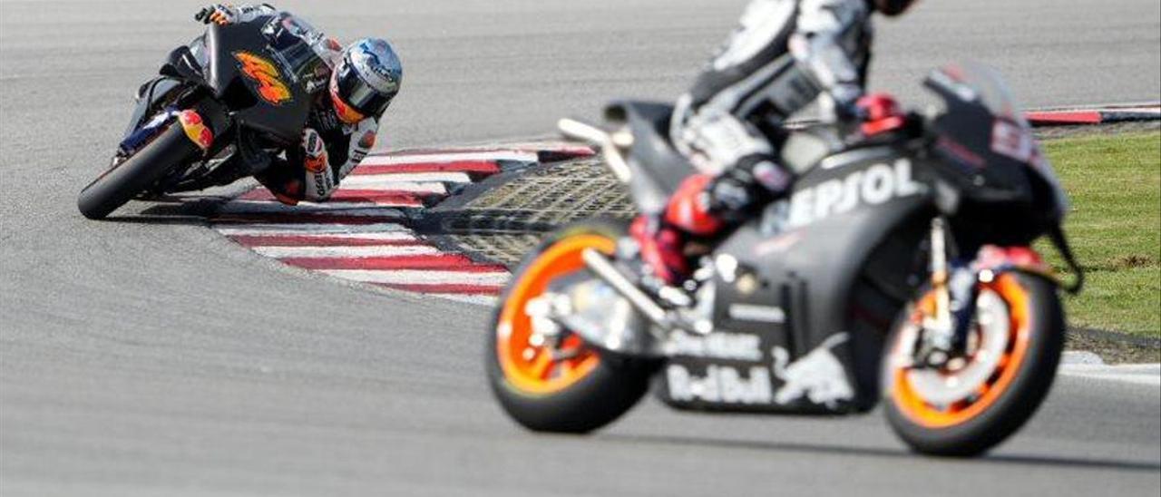 Marc Márquez (Honda), en primer término, observa a su compañero Pol Espargaró, trazando una curva en Sepang.