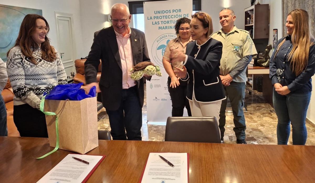 El alcalde sonríe al recibir la tortuga de peluche, uno de los regalos de la directora de los Parques Naturales de Costa Rica