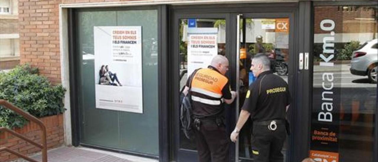 Dos vigilantes cierran en el momento de cerrar la sucursal de CatalunyaCaixa de la calle de Ganduxer donde murió la subdirectora.