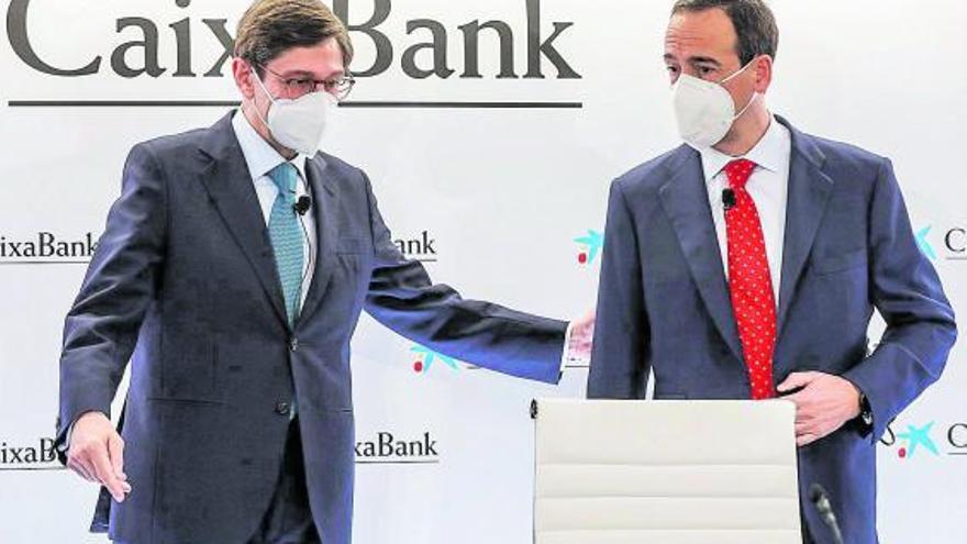 El presidente de CaixaBank, José Ignacio Goirigolzarri (izquierda), y el consejero delegado de la entidad, Gonzalo Gortázar, 
ayer a su llegada a la rueda de prensa celebrada en Valencia.  | | ROBER SOLSONA