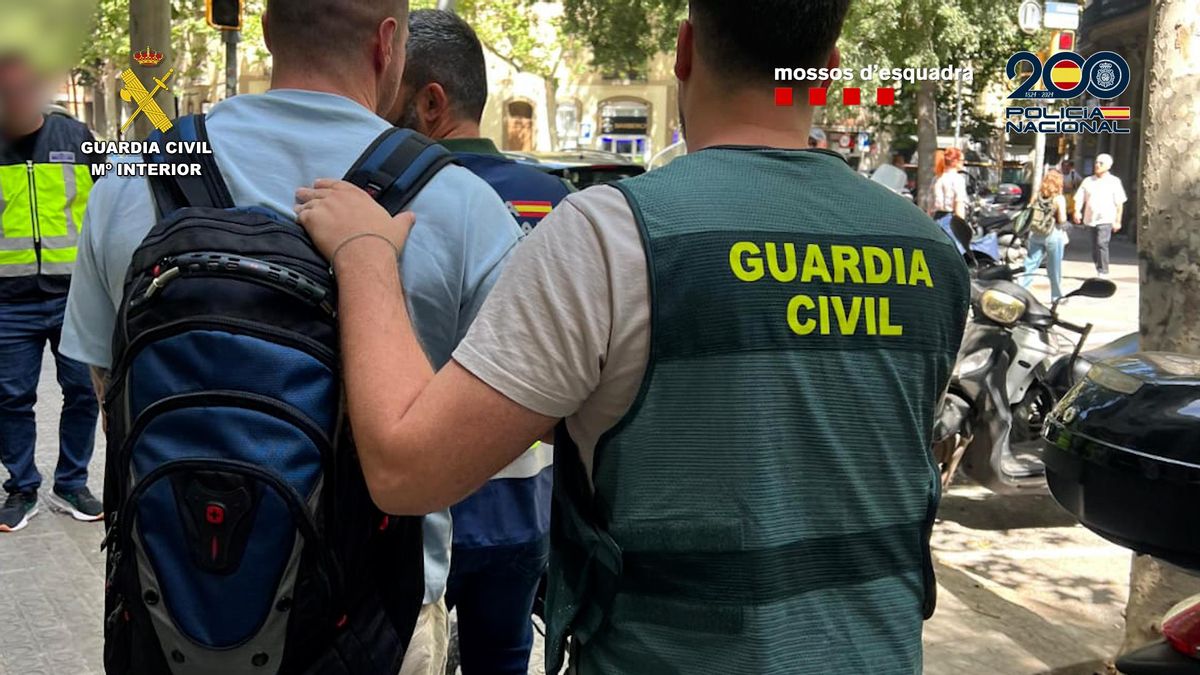 Varios agentes trasladan a uno de los detenidos.