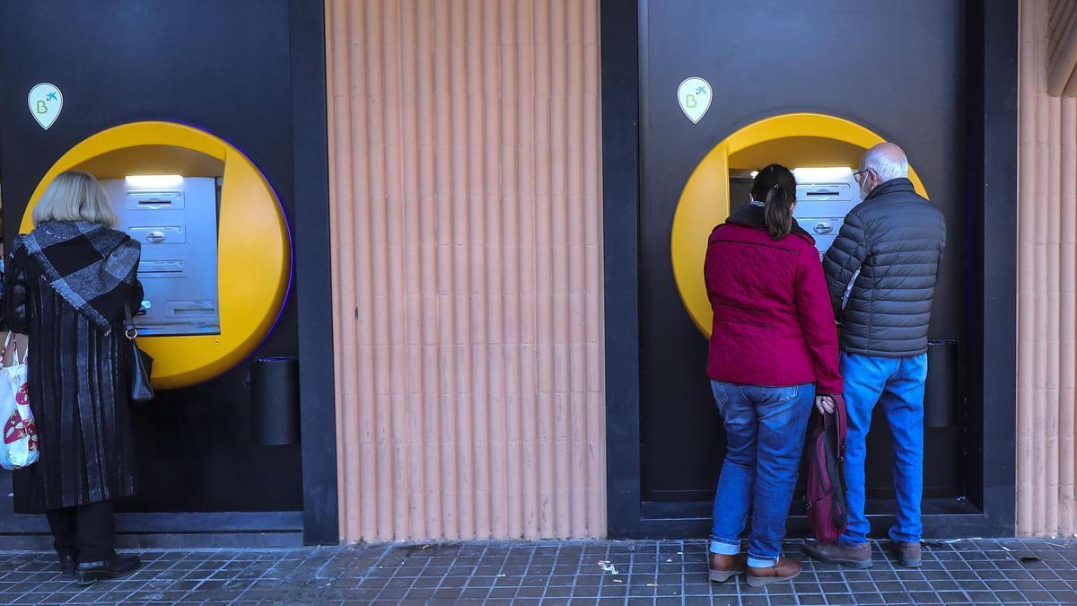 Varios clientes sacan dinero de un cajero de un banco en València