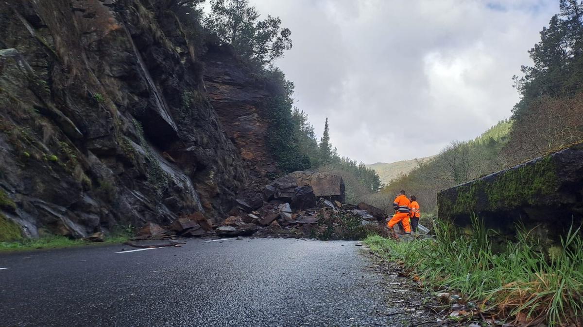 Técnicos de conservación de carreteras analizan el argayo, este sábado a mediodía.
