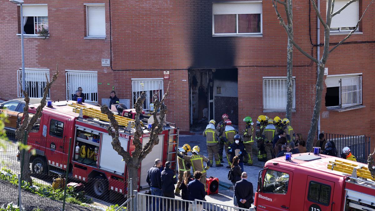 Bomberos junto a una vivienda incendiada.