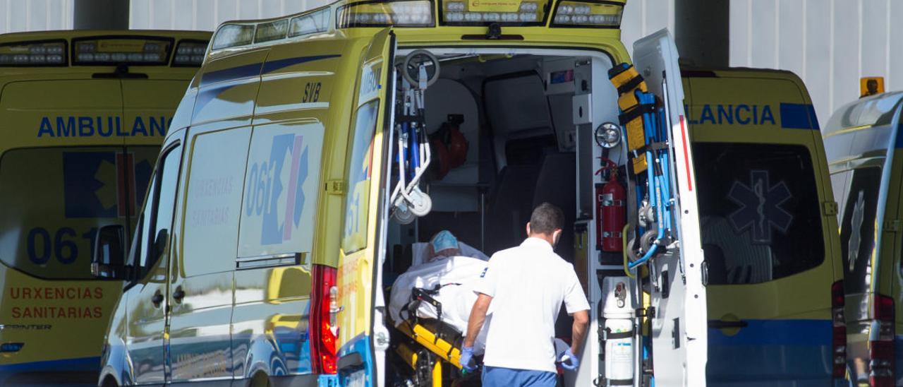 Un sanitario baja de una ambulancia a un paciente.