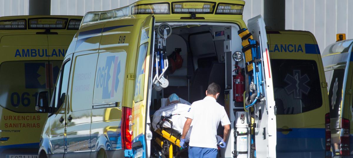 Un sanitario baja de una ambulancia a un paciente.