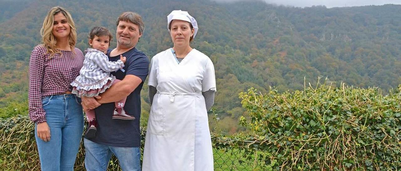 Regiane Alves Da Silva, José Manuel López con la hija de ambos, María, en brazos, y Leonides Marcos Rodríguez, en el exterior del local.