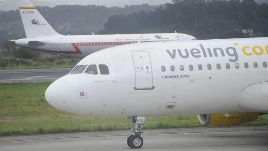 Un avión de Vueling, en primer término, en la pista de Alvedro.