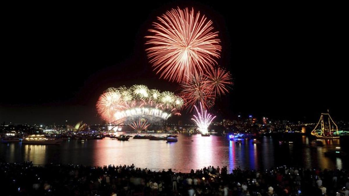 Miles de personas disfrutan de los fuegos artificiales en Sídney celebrar el Año Nuevo.