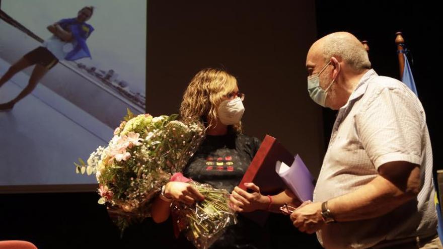 El alcalde Jaime Menéndez Corrales entrega a la homenajeada un ramo de flores y una placa. | F. R.