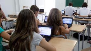 Alumnos de secundaria, manejándose en clase con ordenadores.