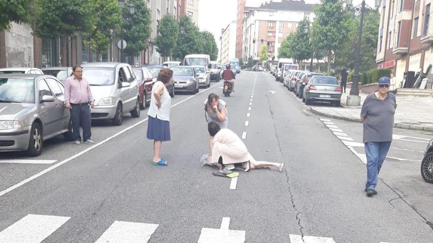 La mujer herida, tirada en el suelo, siendo asistido.