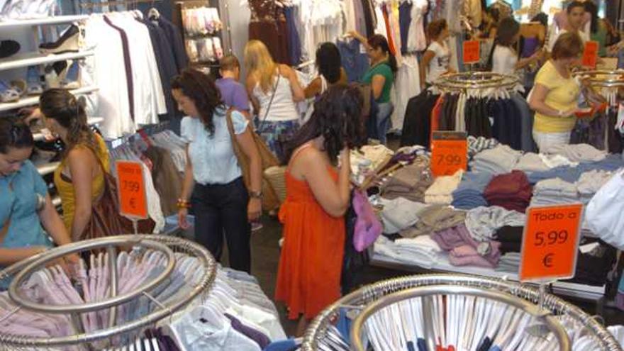 Un grupo de clientes se interesan pro diferentes artículos en una tienda de ropa. | la provincia  / dlp