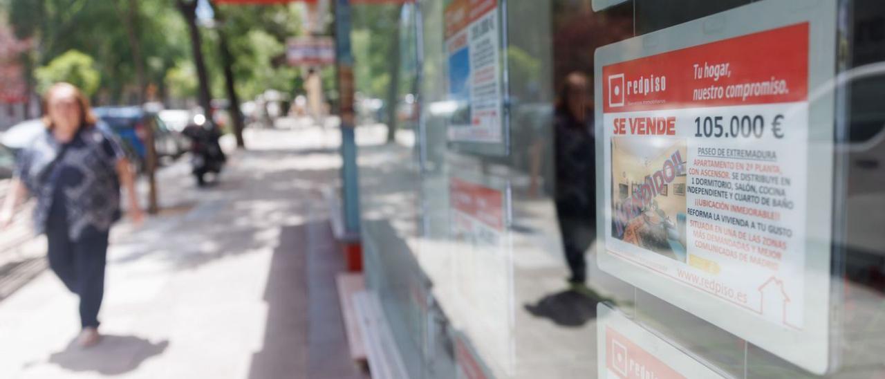 Escaparate de una inmobiliaria con ofertas de venta de pisos.