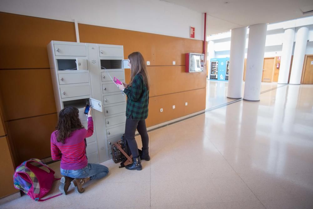 Alumnos usando las taquillas para cargar dispositivos