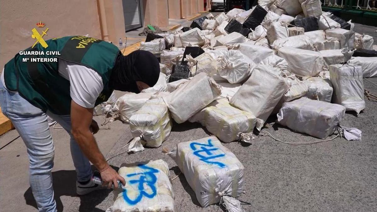 En el muelle del Arsenal de Las Palmas de Gran Canaria, un miembro de la UCO numera fardos de cocaína descargados del carguero Arconian en la operación Abisal de la Guardia Civil