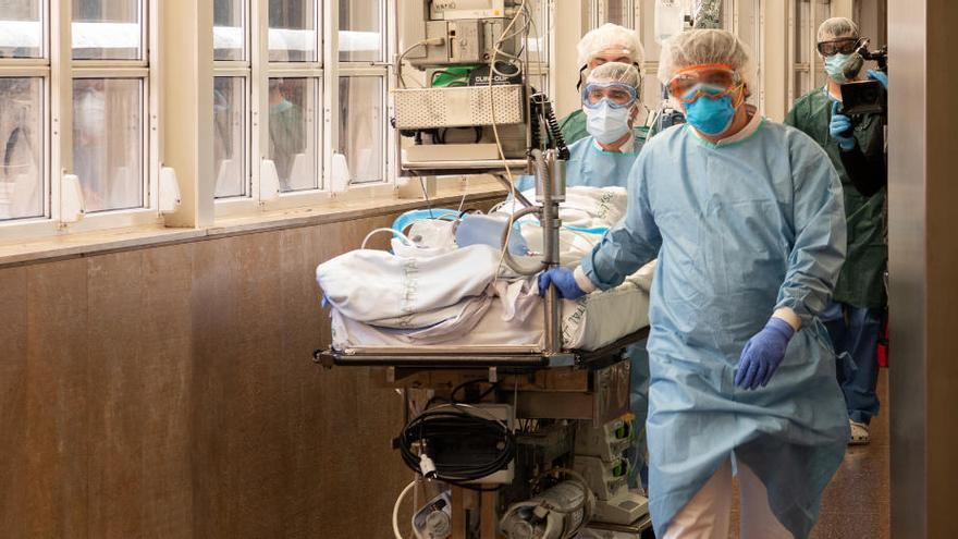 Professionals sanitaris traslladen un pacient de covid-19 per un dels passadissos de l&#039;Hospital Clínic de Barcelona