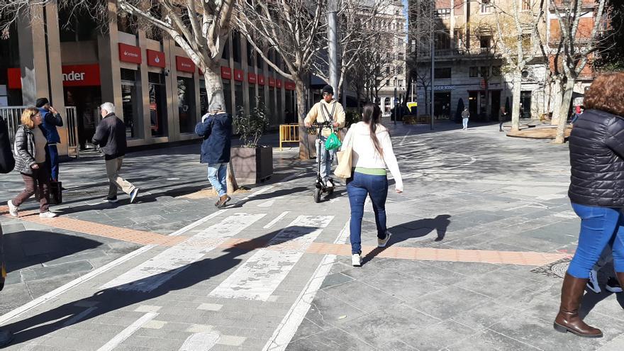 Un patinete circula por el carril bici de la plaza de España en obras.