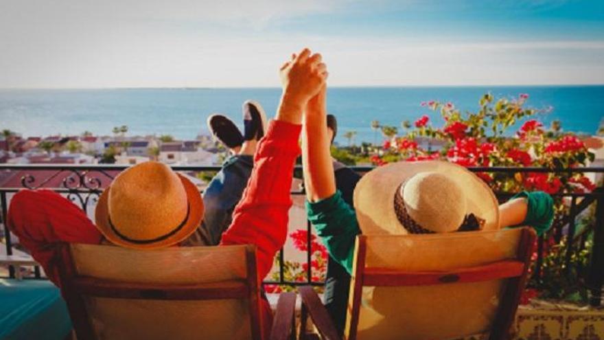 Una pareja disfruta de las vistas desde su balcón.