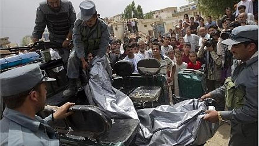 Policías afganos trrasladan el cadáver de uno de los talibanes abatidos.