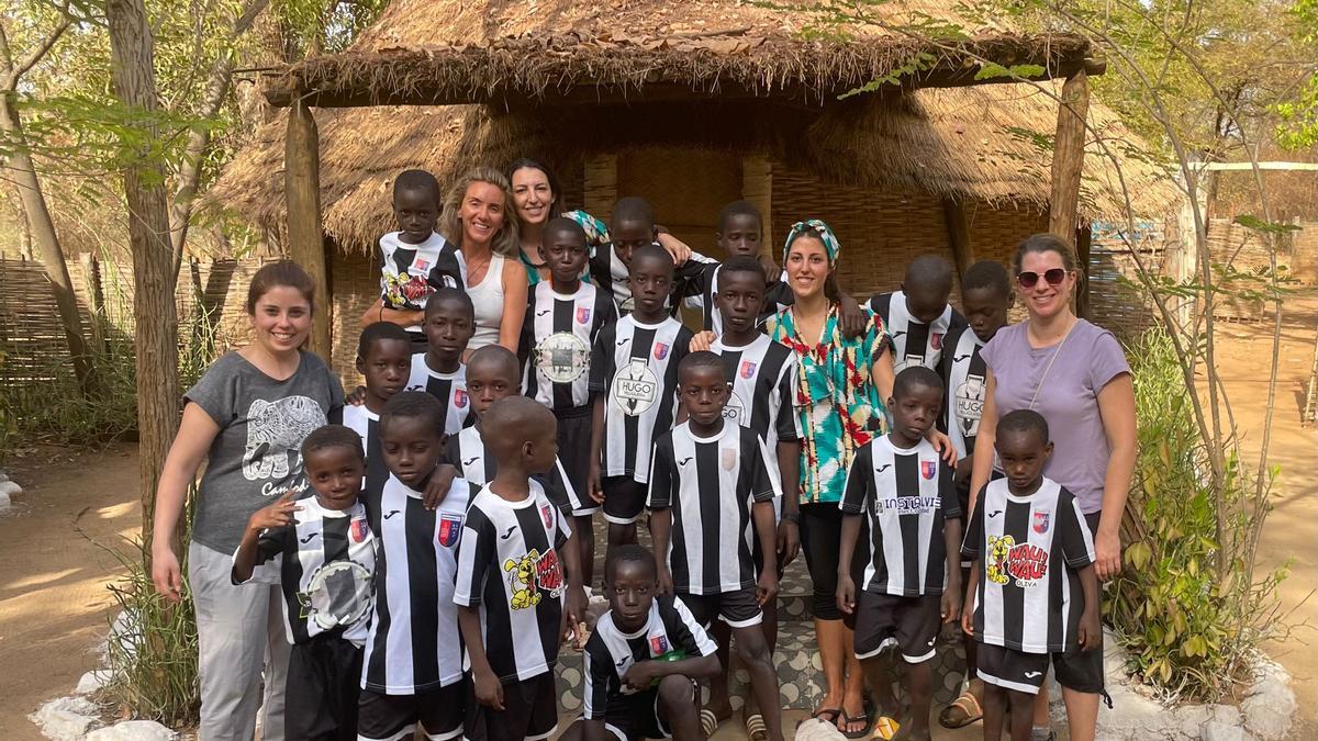 Los niños de Senegal, vestidos con los equipajes del Benirredrà CF, con las voluntarias de la ONG de Gandia