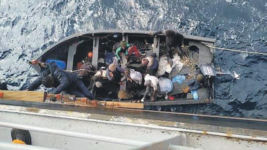 Imagen de los migrantes cuando subían hasta uno de los buques que los rescató en alta mar el pasado sábado.