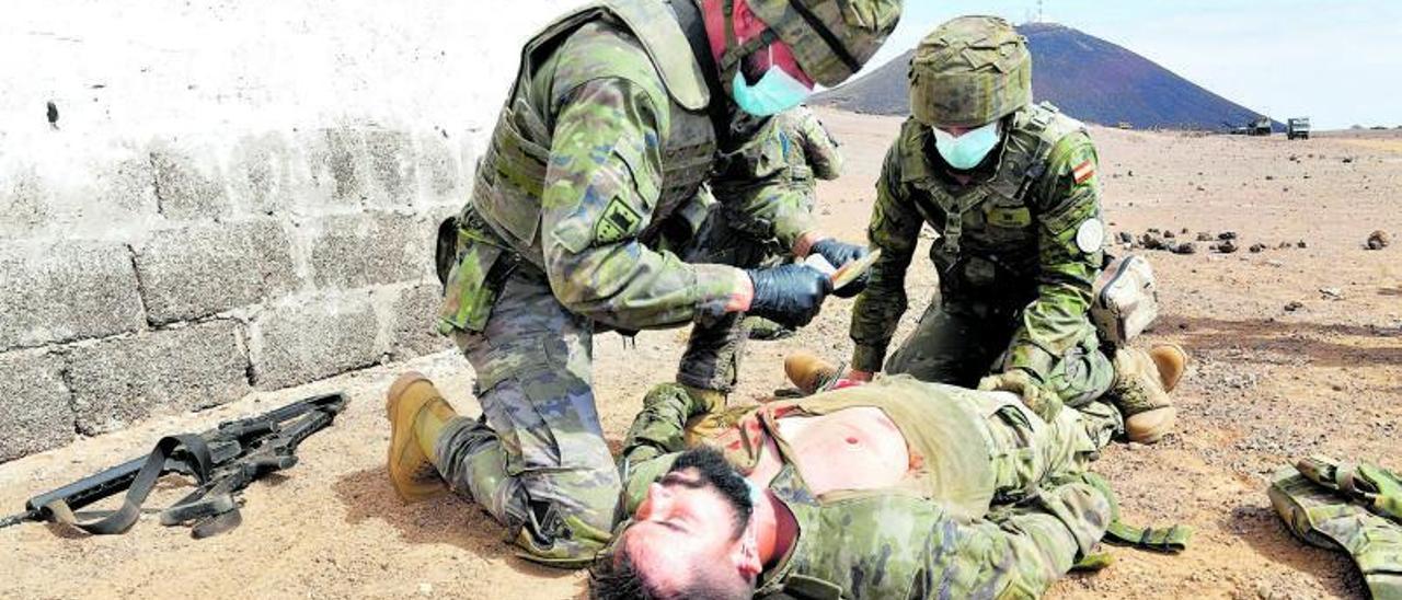 Simulación por parte de los efectivos de la Brigada Canarias XVI auxiliando a una persona herida de bala en la pierna y el pecho.