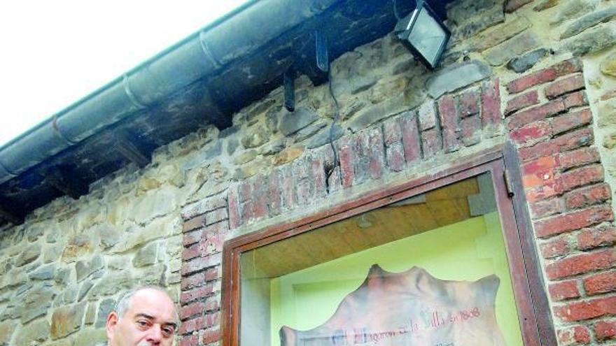 A la izquierda, Daniel Fernández, junto al pergamino que narra el enfrentamiento. A la derecha, miembros de la Corporación, en el interior del bar.