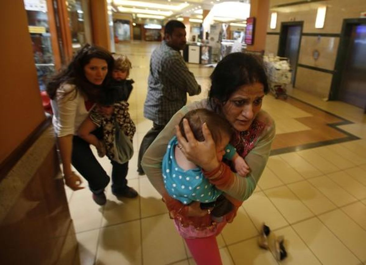 Una dona abraça el seu fill mentre fuig del centre comercial Westgate a Nairobi, aquest dissabte.