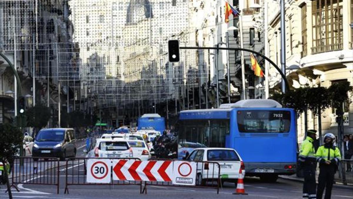 Restricciones 8 Dos policías municipales controlan el acceso de vehículos a la Gran Vía madrileña.