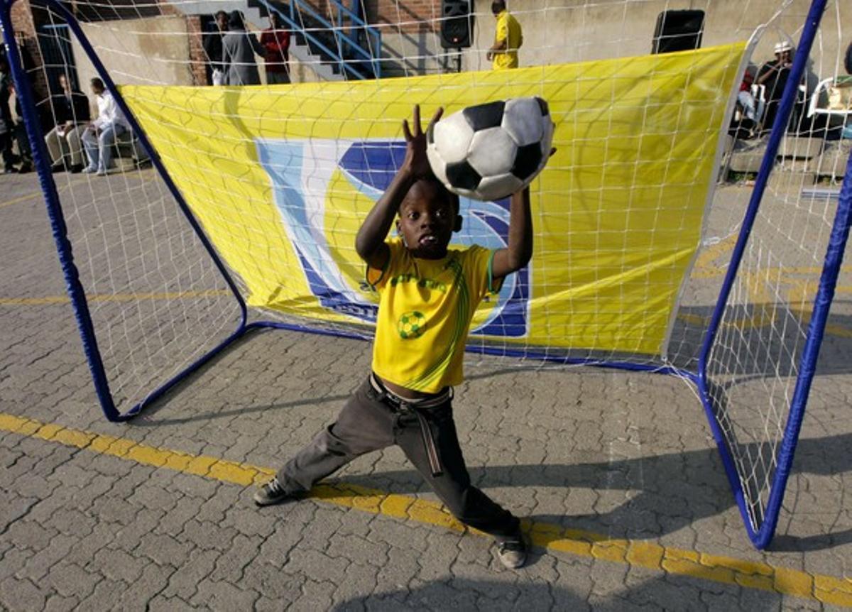 Un nen para una pilota mentre juga a futbol al centre esportiu de l’Alexandra Stadium, a Johannesburg.