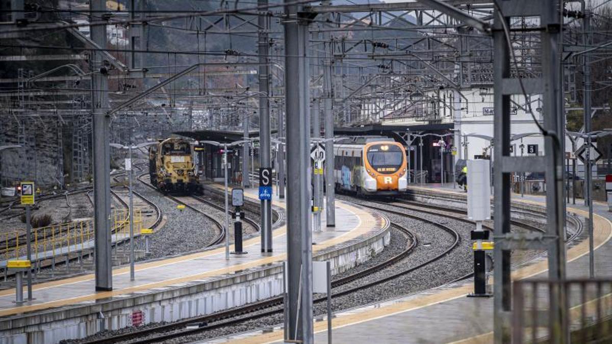 Platja de vies de l'estació de Renfe de Manresa, amb un tren de passatgers a les andanes