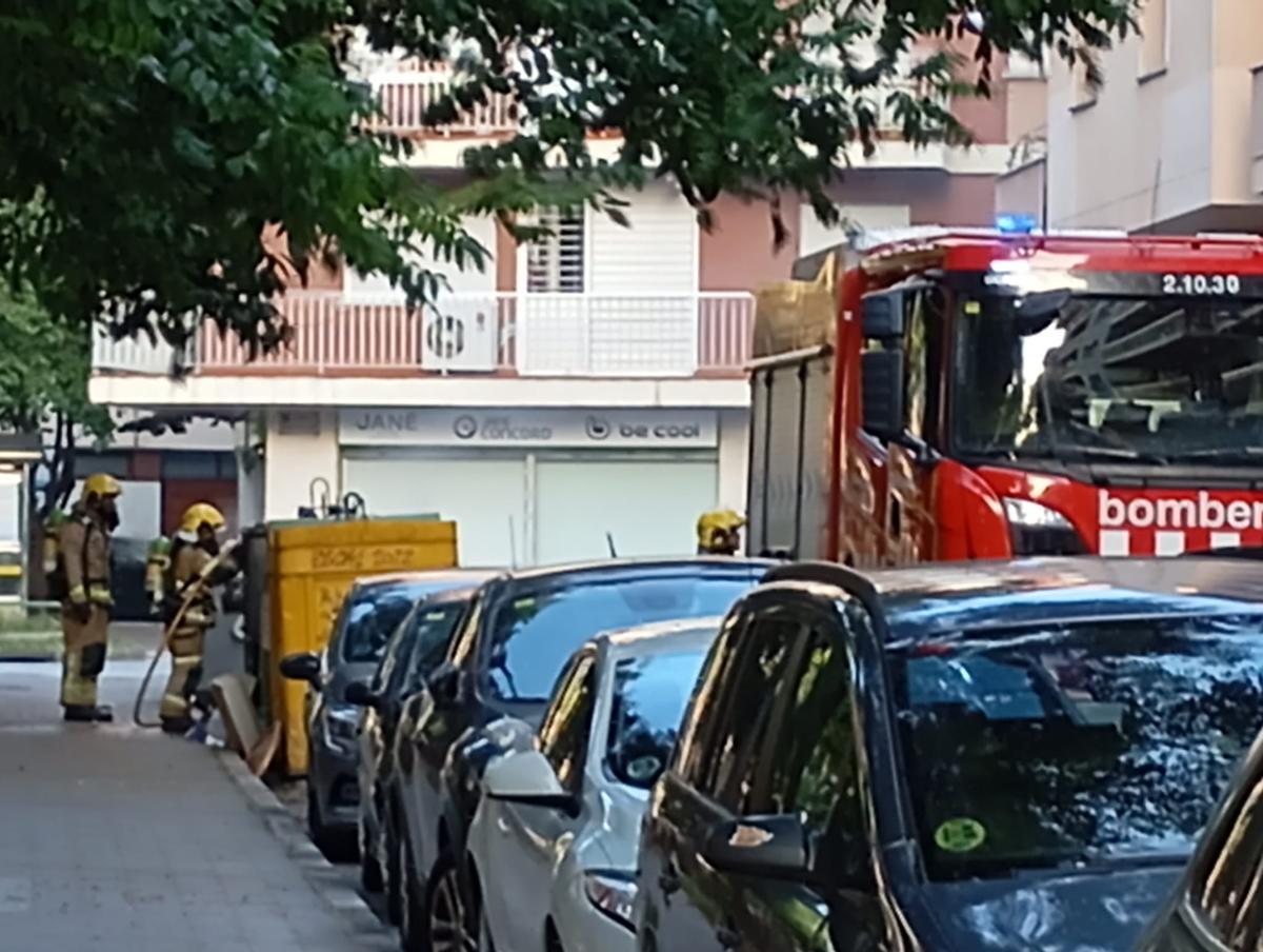 Bombers apagant l'incendi del contenidor del carrer Josep Roca i Bros.