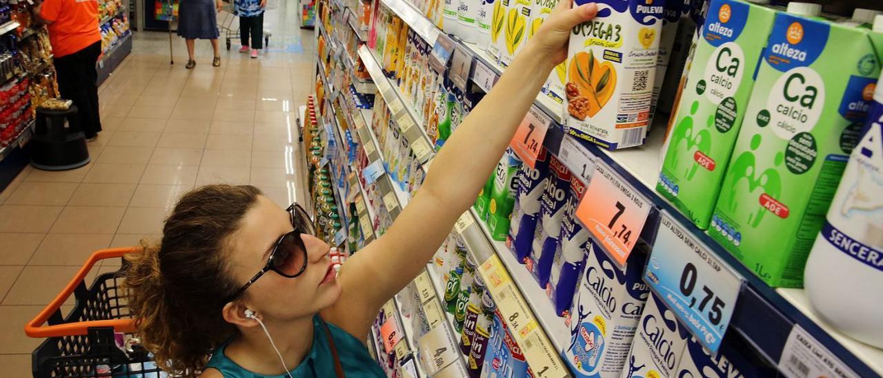 Una mujer escoge un cartón de leche en un supermercado. |   // R.C.