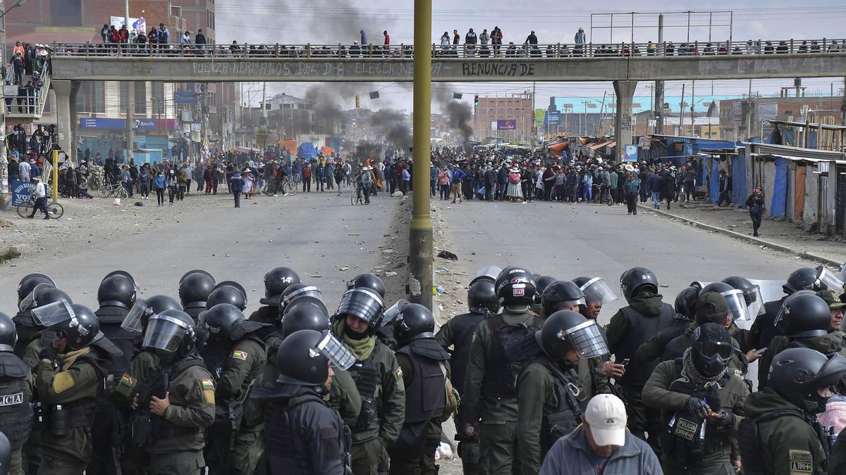 Policías controlan a los seguidores del presidente Luis Arce y del expresidente Evo Morales durante algunos enfrentamientos este domingo, en la ciudad de El Alto (Bolivia).