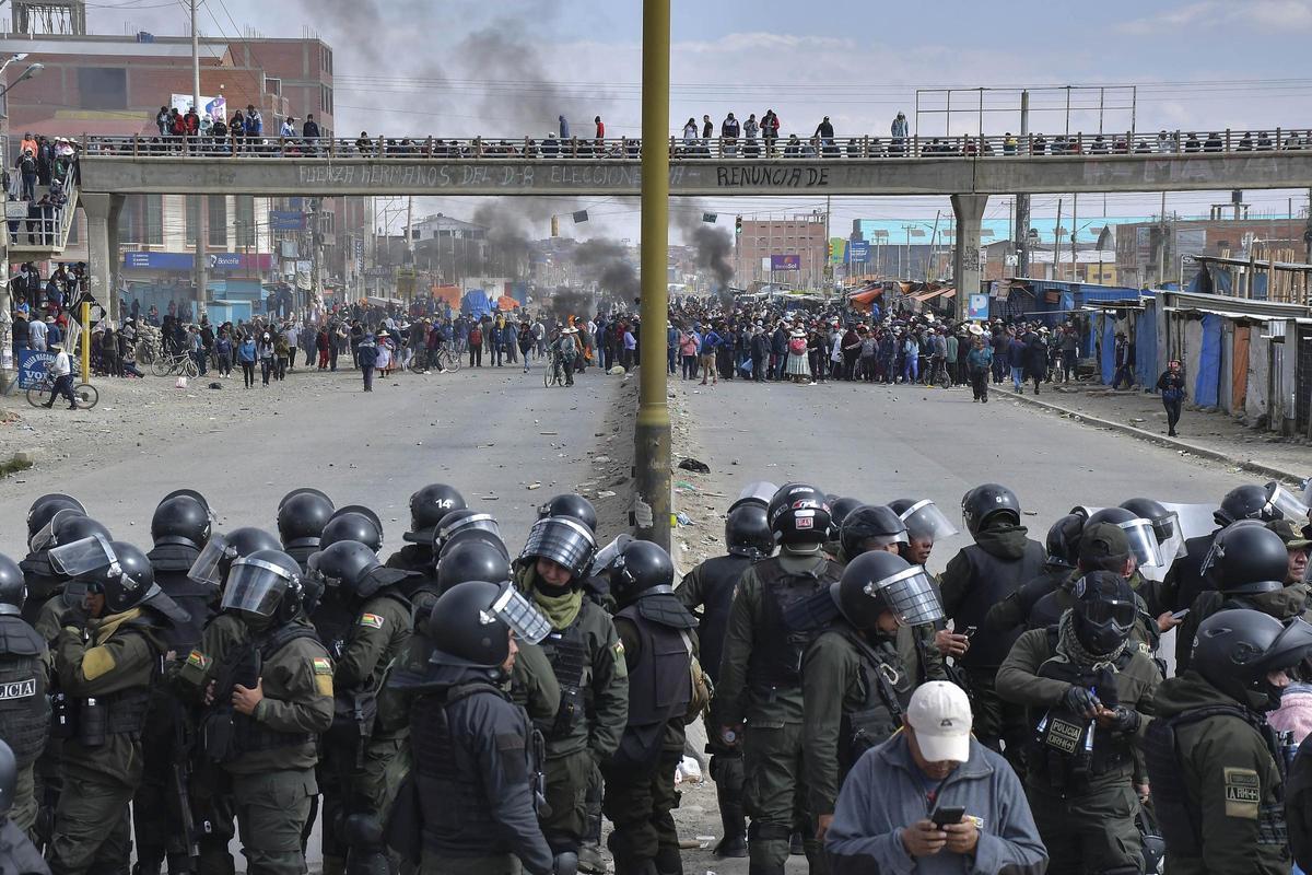Policías controlan a los seguidores del presidente Luis Arce y del expresidente Evo Morales durante algunos enfrentamientos este domingo, en la ciudad de El Alto (Bolivia).