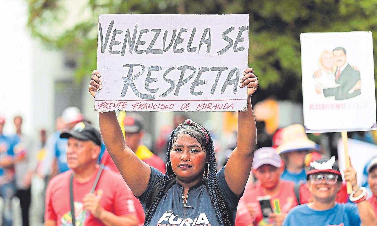 Una mujer con un cartel en una marcha en favor de Nicolás Maduro.