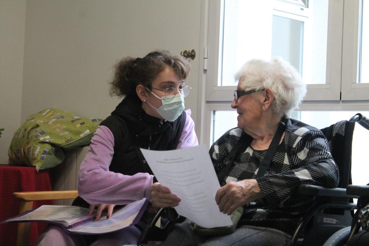 Una estudiante del centro con una de las mujeres mayores de la residencia.