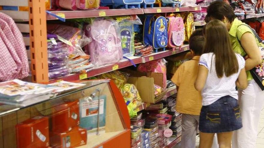 Varios niños eligen mochilas en un comercio.