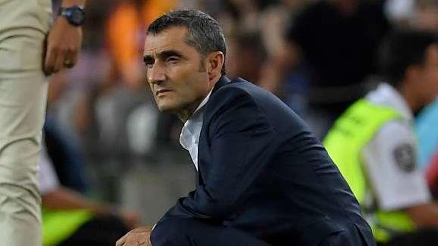 Valverde examina el juego de su equipo agachado sobre el césped