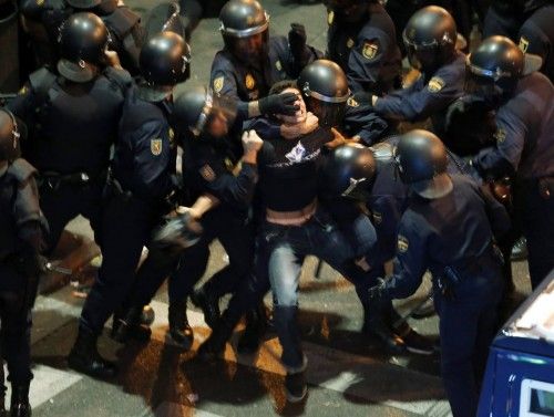 Policías antidisturbios reducen a un joven durante la jornada de huelga general de España.