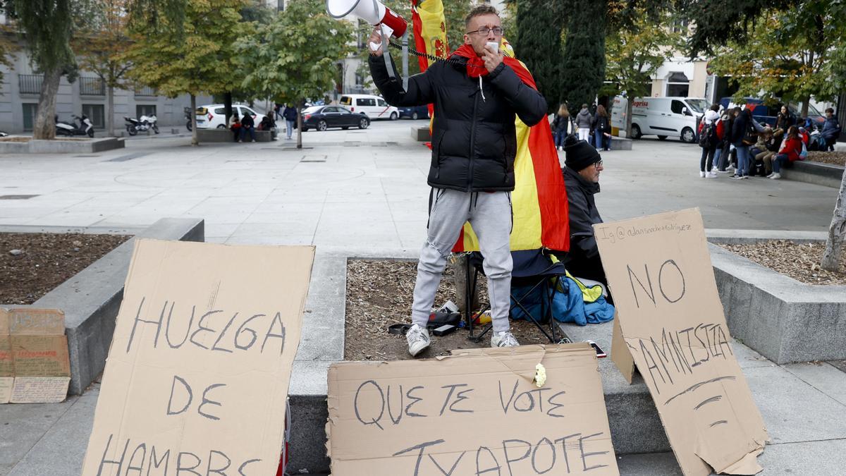 Un joven se encadena frente al Congreso como protesta contra una posible ley de amnistía.