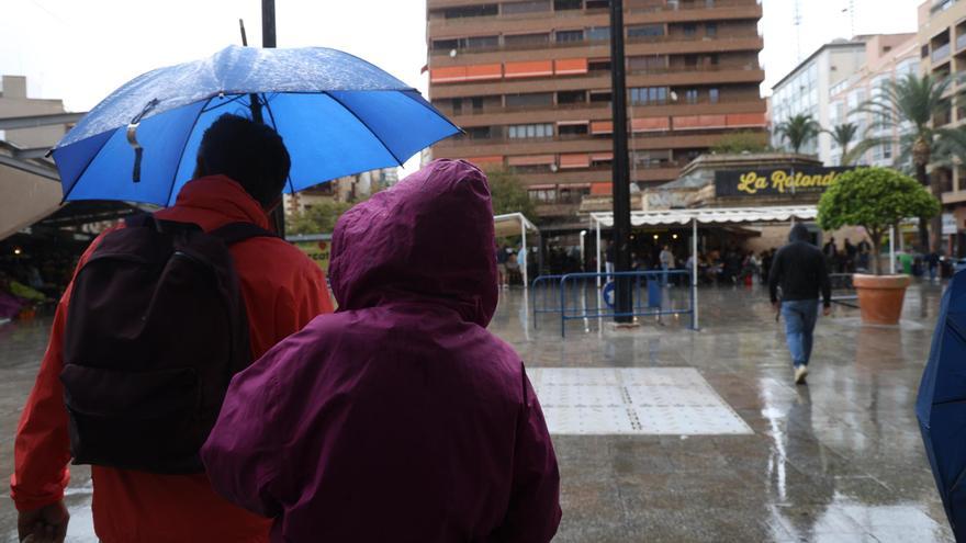 La lluvia obliga a los alicantinos a sacar chubasqueros y paraguas
